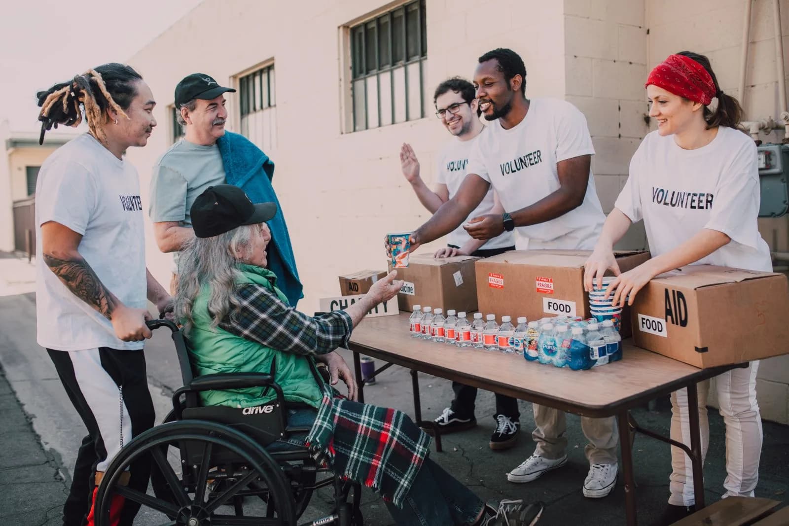 Volunteers handing out food and supplies at a community table