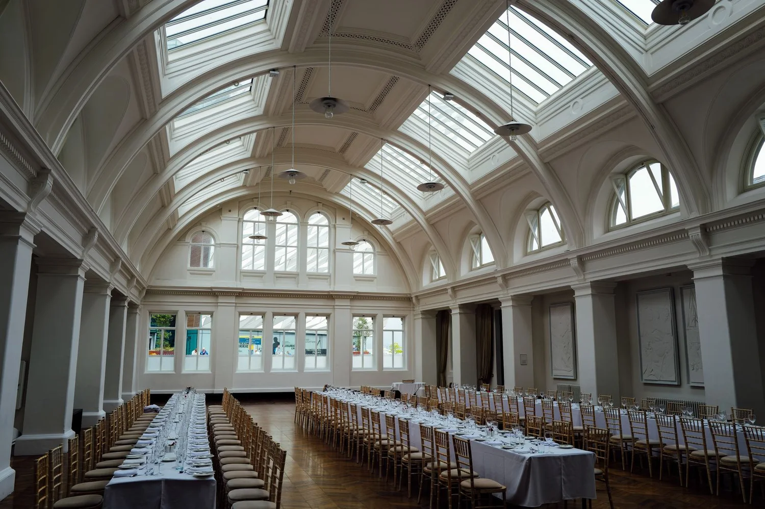 A spacious event hall with arched skylights and long banquet tables